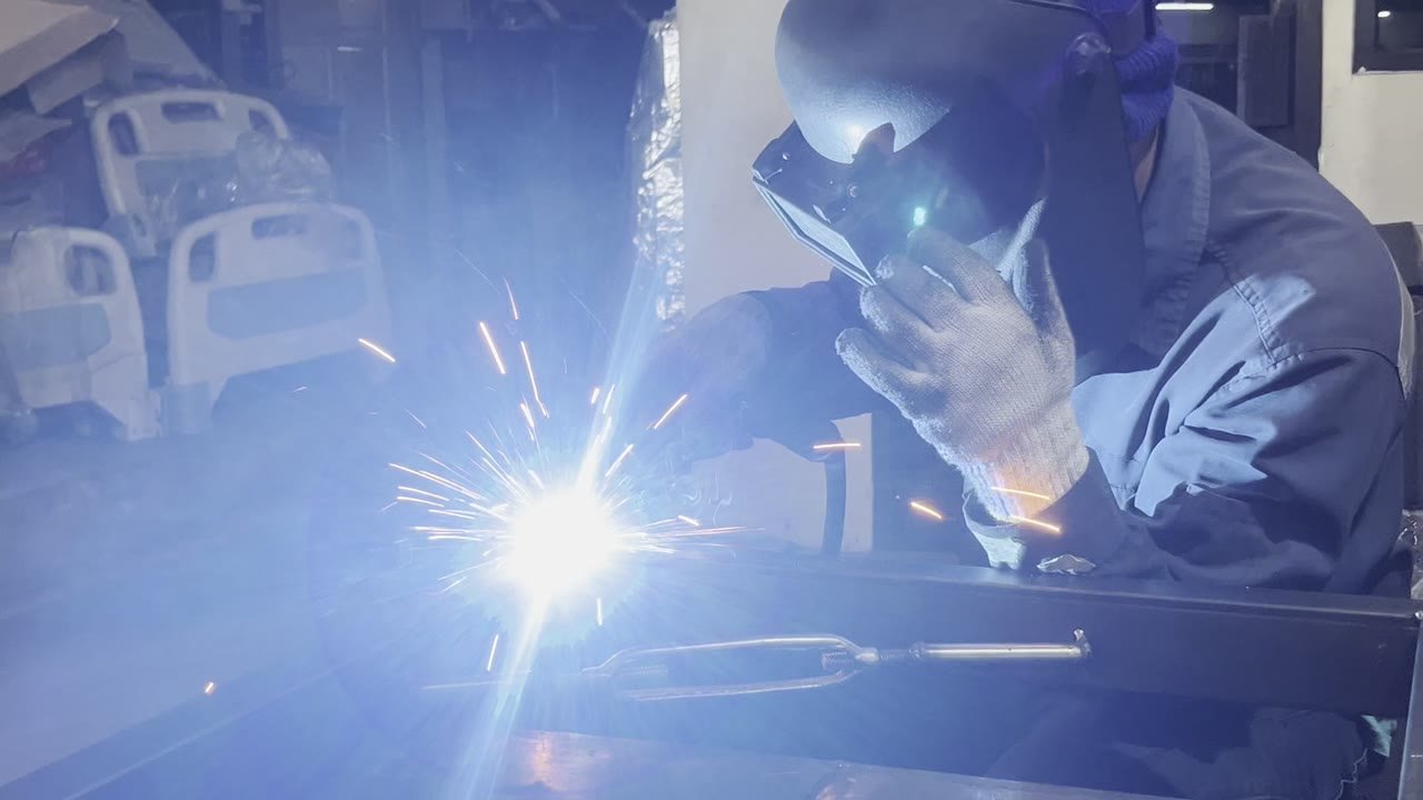 Operator melakukan pengelasan TIG pada pelat stainless steel di bengkel fabrikasi Rekayasa Manufaktur